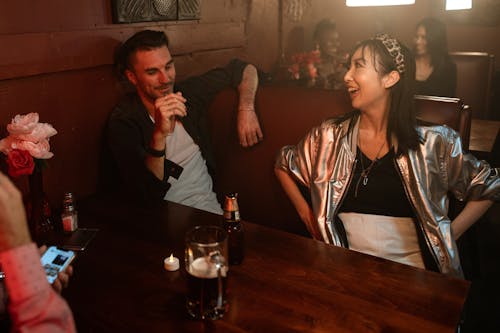 Man and a Woman Having a Conversation inside a Bar