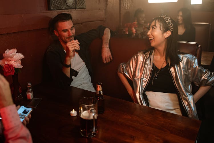 Man And A Woman Having A Conversation Inside A Bar