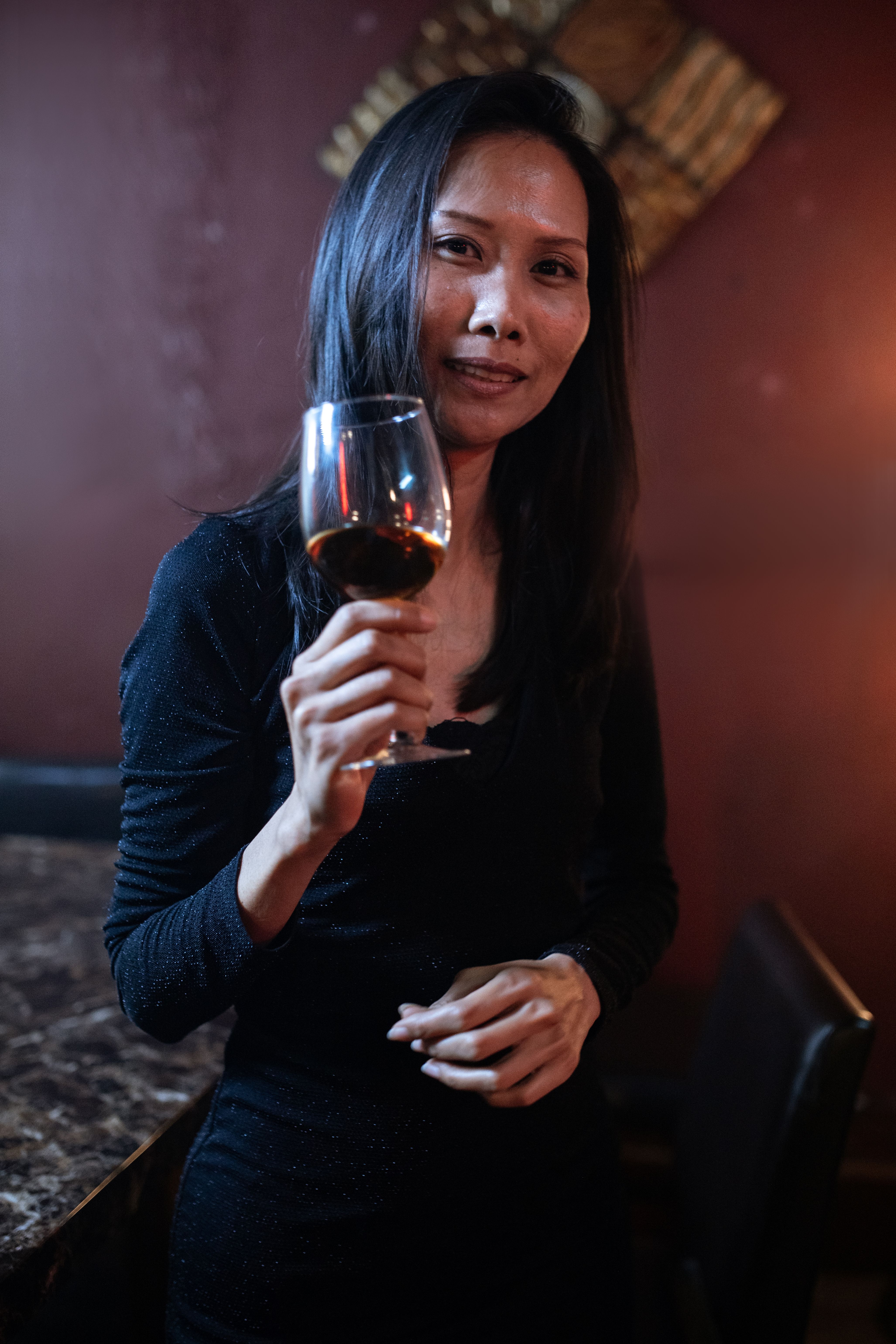 A Beautiful Woman in Black Dress Holding a Wine Glass · Free Stock Photo