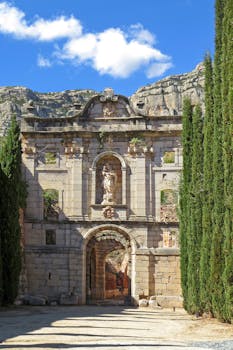 Stunning view of the medieval Escaladei monastery ruins in Spain with clear blue sky.