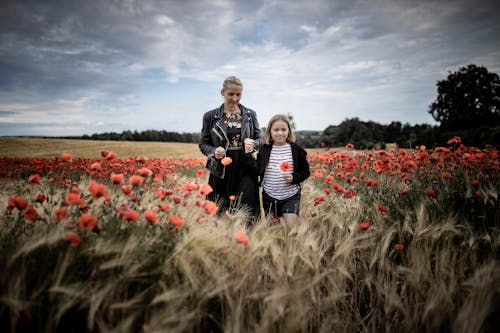 Mother and Daughter among Poppies in Field