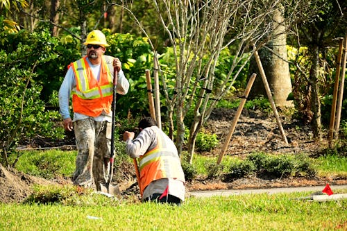 Two Male Construction Workers Digging in Soil