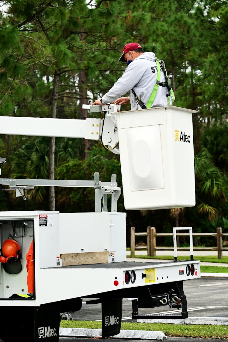 A Worker Pushing Buttons On A Bucket Truck