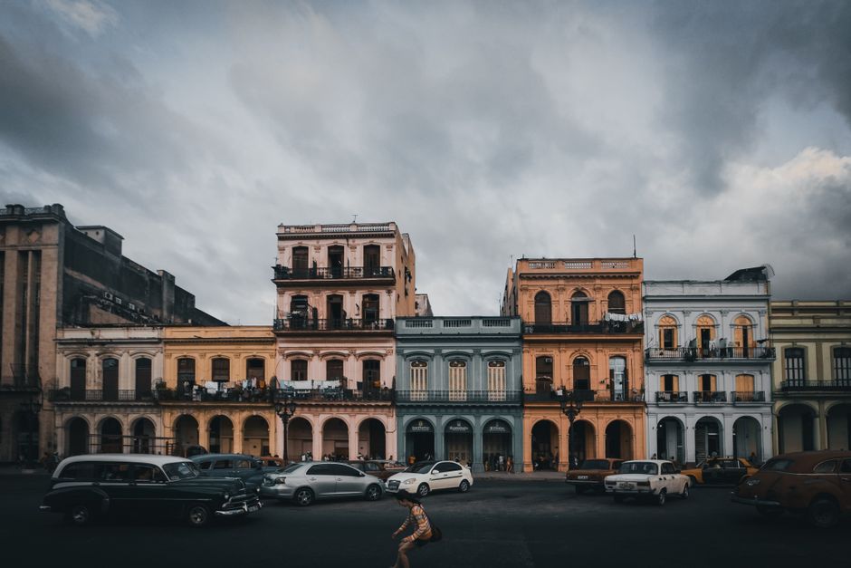 Classic colonial buildings in Old Havana under a cloudy sky.