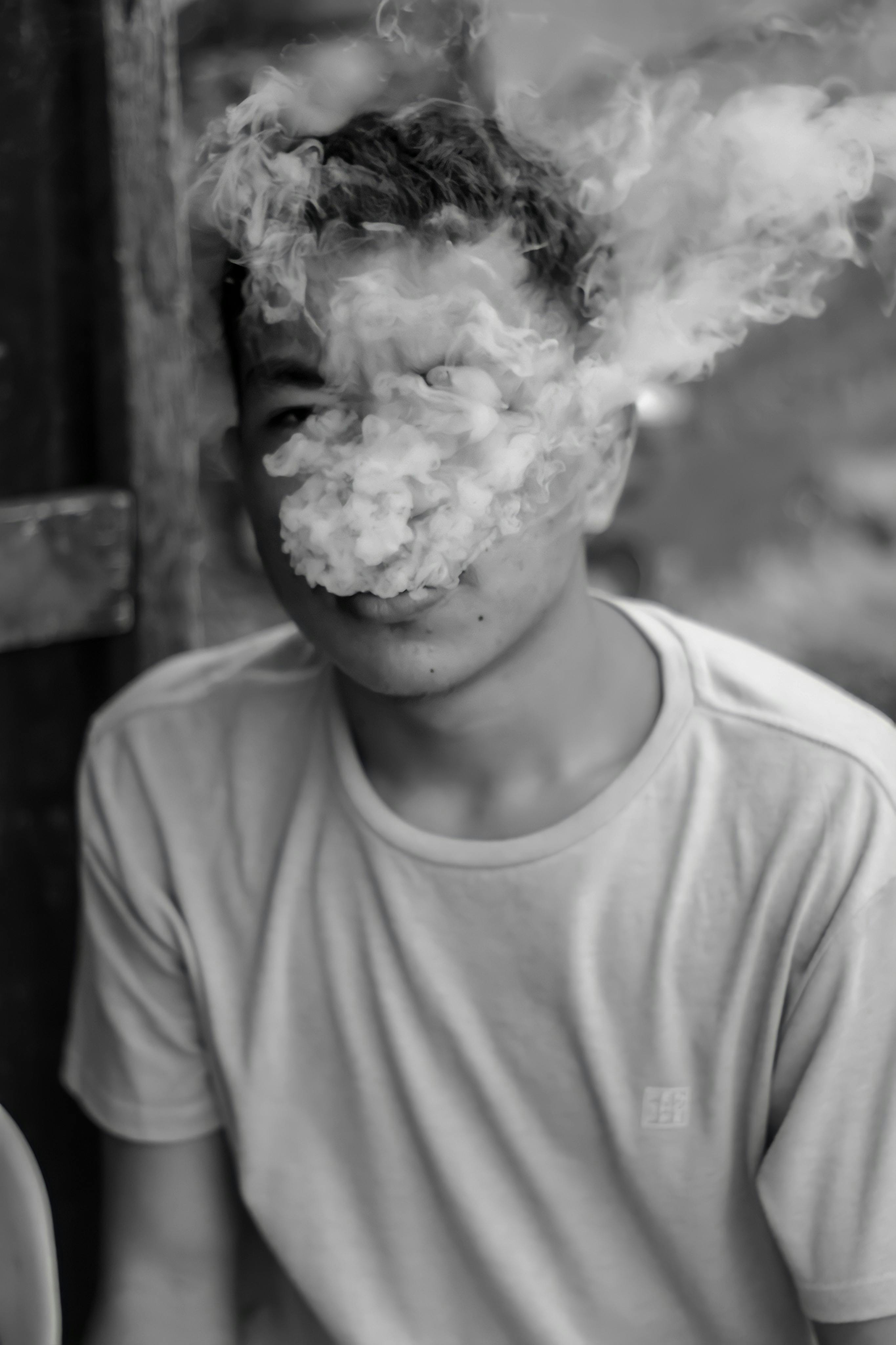 young male student in smoke of cigarettes