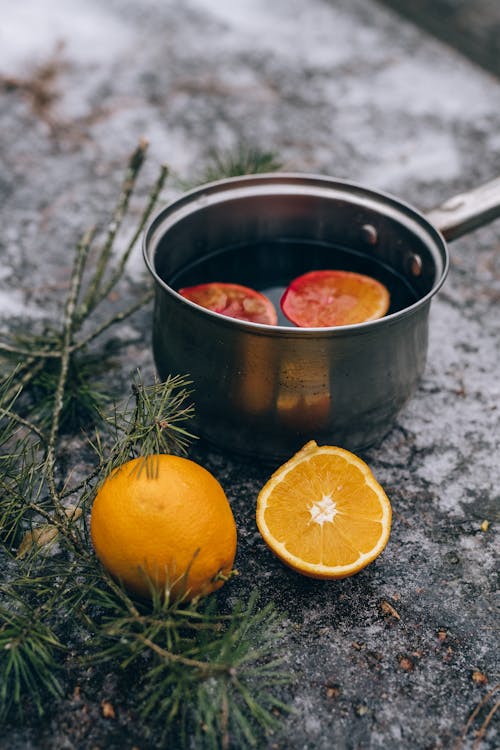 Cubo De Acero Inoxidable Con Fruta Naranja Al Lado