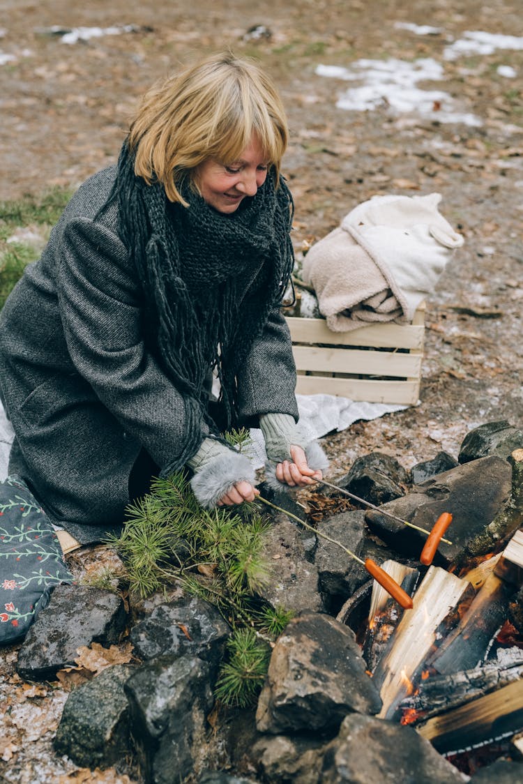 A Woman Cooking On The Campfire