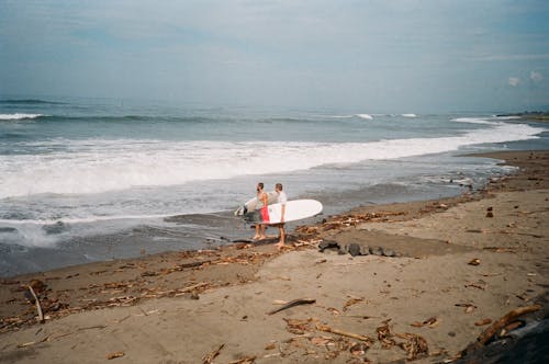 

Men Holding Their Surfboards on the Shore