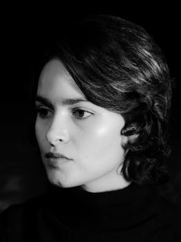 A striking black and white studio portrait of a woman with short hair, exuding elegance and confidence.