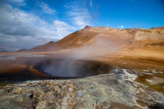 Geyser with Steam Coming out and a Hill in a Distance 