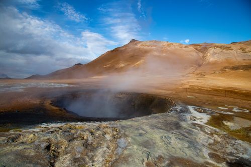 Free A stunning view of steam rising from the geothermal fields in Iceland under a bright blue sky. Stock Photo
