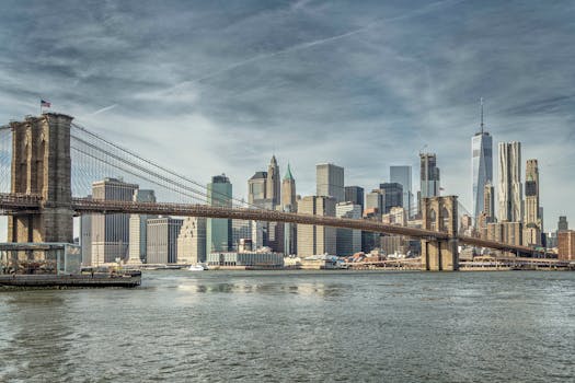 Beautiful view of Brooklyn Bridge leading to the NYC skyline on a clear day.