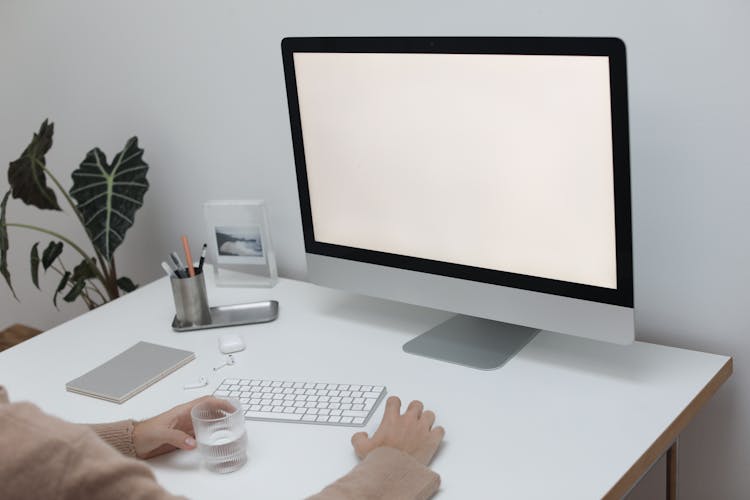 Crop Person With Computer And Wireless Keyboard