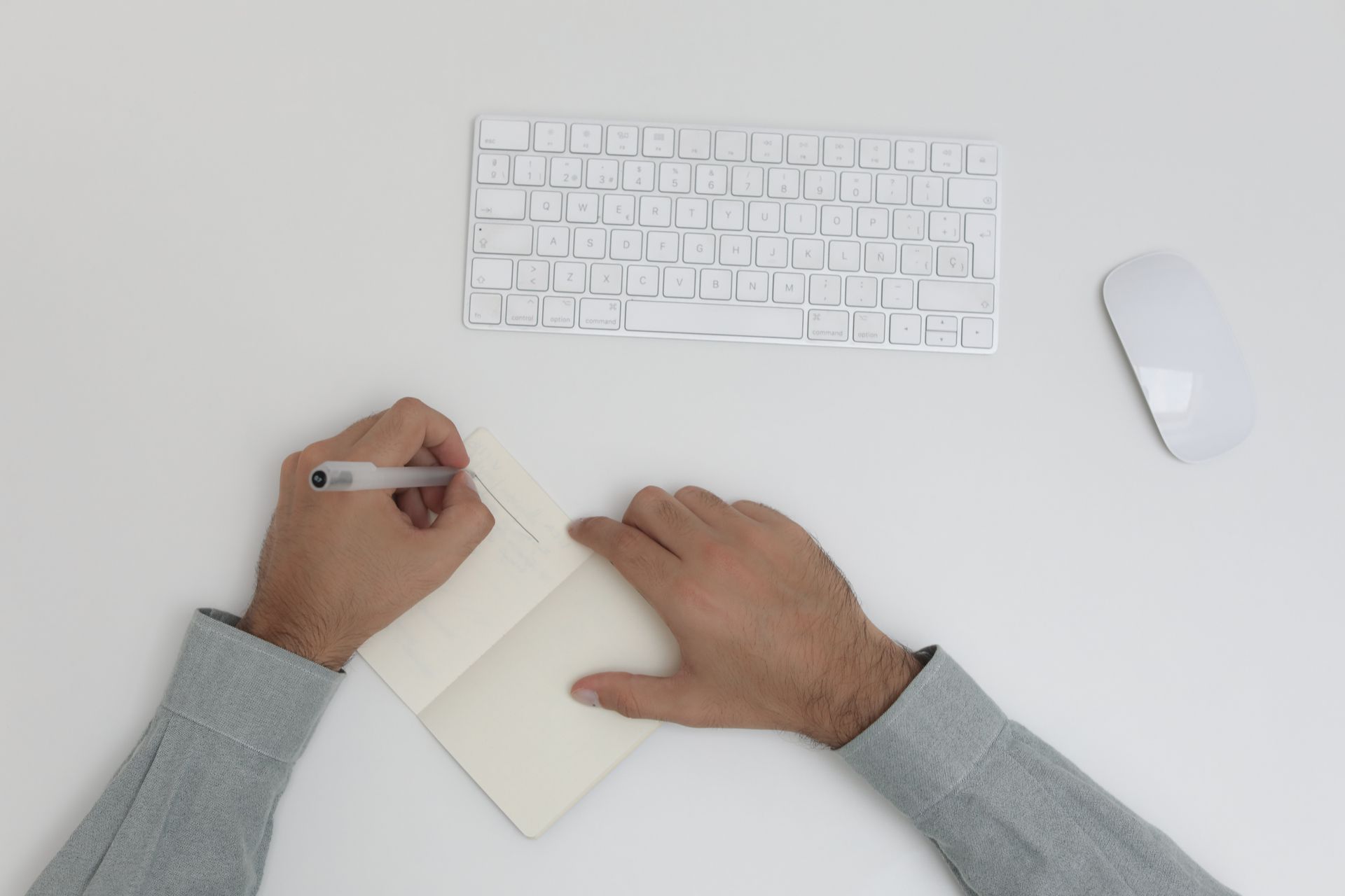 Overhead view of a minimalist workspace with a notebook and keyboard.