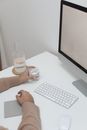 Crop person with glass and computer