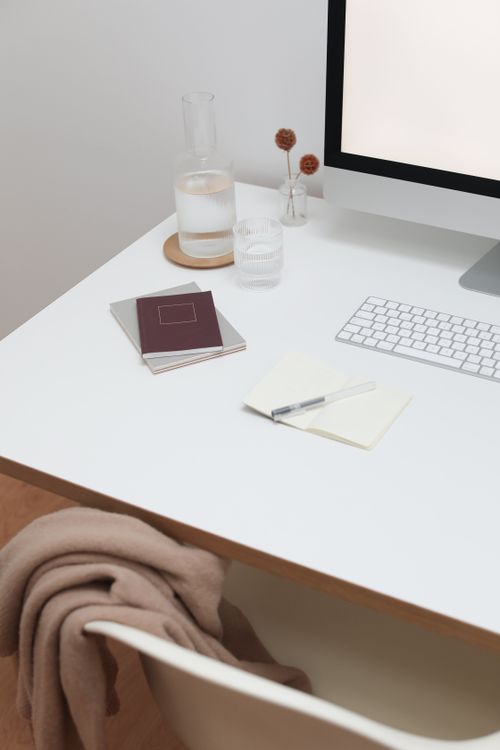 Free Workplace with wireless keyboard and monitor near notebooks on white wooden table in room Stock Photo