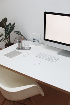 High angle of contemporary workplace with computer and office supplies near earbuds on table