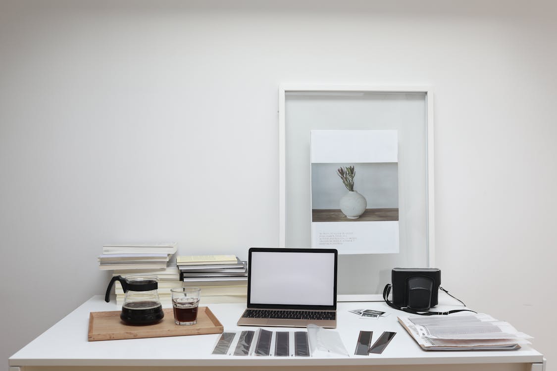 Interior of contemporary workspace with laptop near coffee and roll film on table