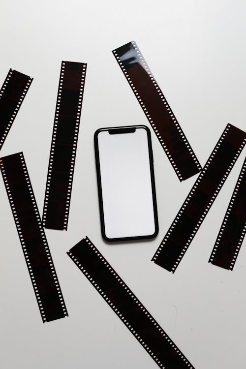 Film tapes scattered on table near smartphone