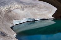 Stunning icy shoreline of a lake in Iceland reflecting pristine snow and ice formations.