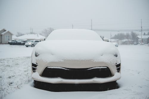 Car covered with snow parked in town
