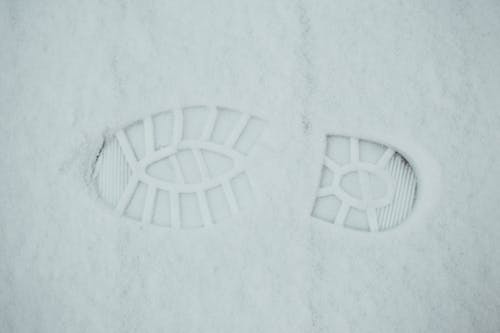 From above of textured background of footprint on ground covered with snow in winter day