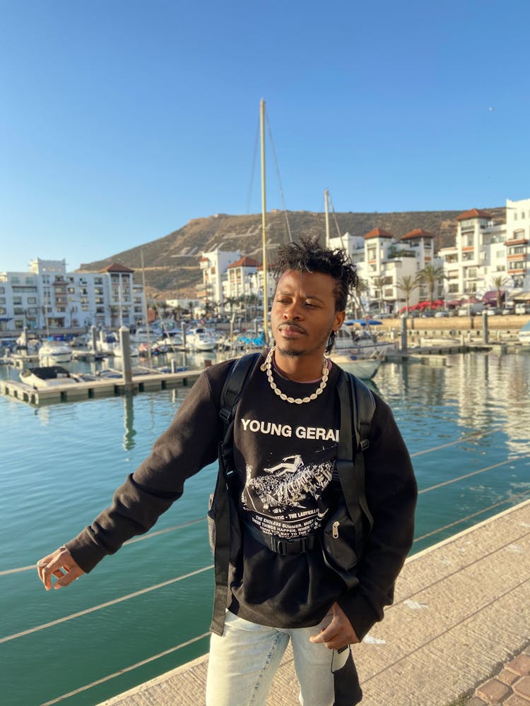 Man In Black Sweater Standing Near The Body Of Water