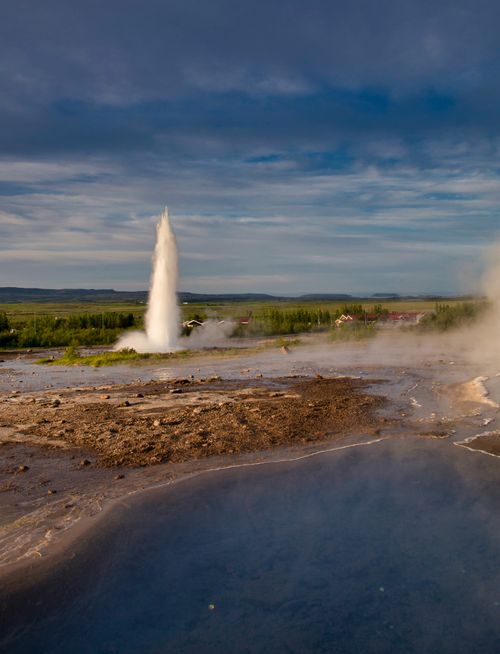 Free Captivating view of an erupting geyser under a blue sky in Iceland's geothermal landscape. Stock Photo