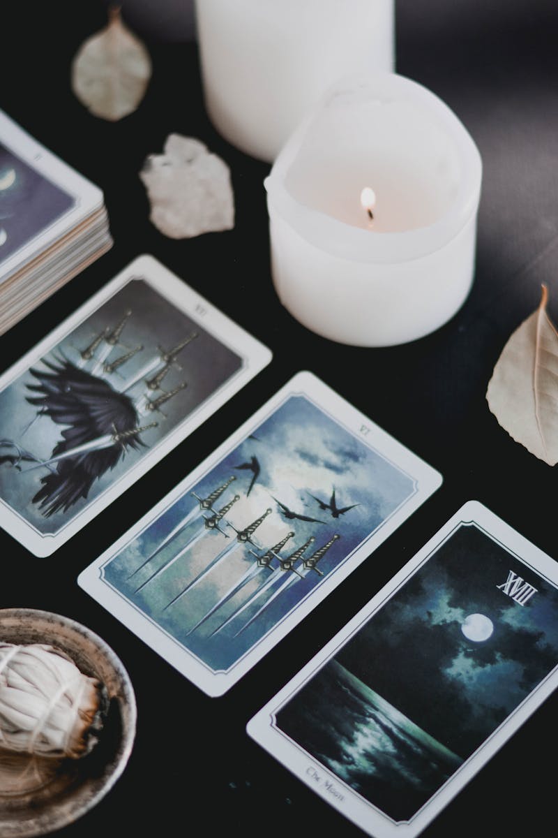 Tarot cards and candles on a black surface, sharp and minimal mystical atmosphere
