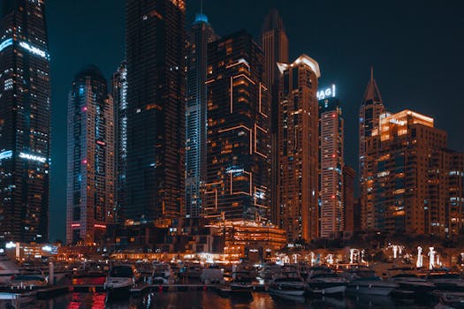 Captivating night view of Abu Dhabi's skyline featuring illuminated skyscrapers and yachts in the foreground.