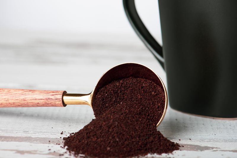 Coffee scoop and roasted beans prepared for home brewing