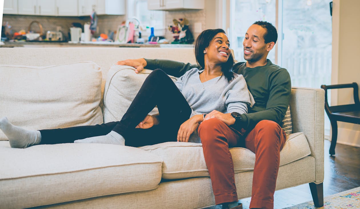 Happy black couple sitting on couch