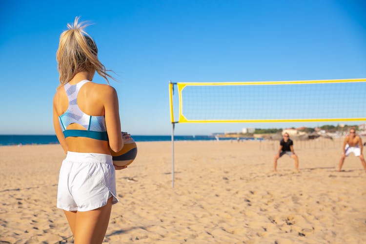 A Woman Playing Volleyball On The Beach