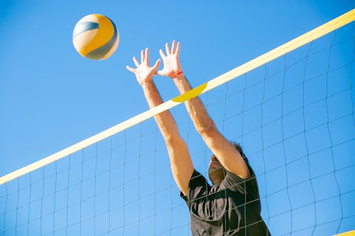 Free Man Blocking a Ball Over the Net Stock Photo