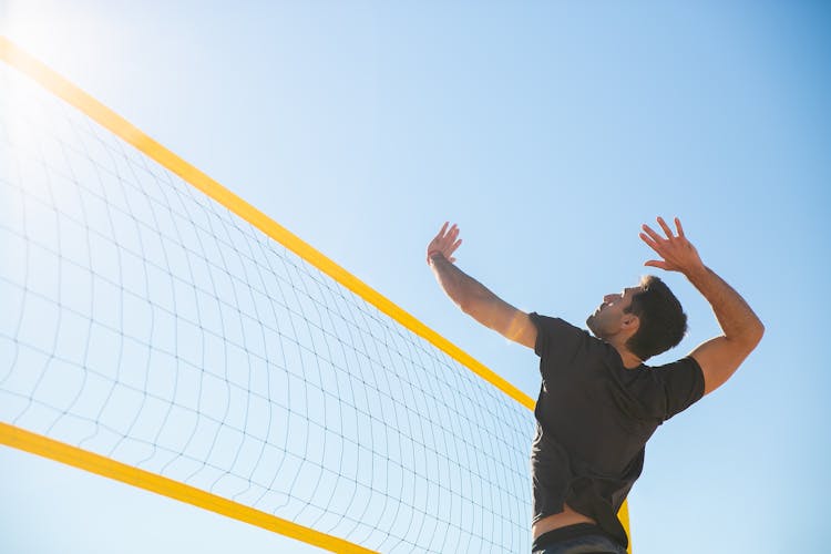 A Man Playing Volleyball On The Beach