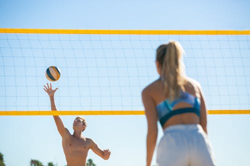 Mujer En Sujetador Deportivo Azul Y Pantalones Cortos Blancos Sosteniendo Voleibol