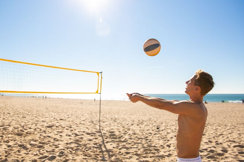 Beachvolleyball-Spieler schlägt den Ball