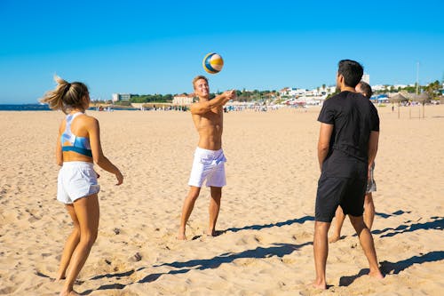 Man In Zwart T Shirt En Witte Korte Broek Gele Volleybal Op Strand Te Houden