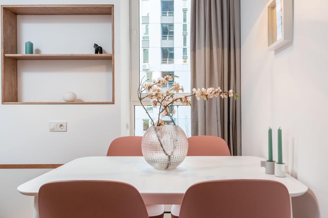 Pendant lighting defining a dining zone Dining table styled with candles and sakura blossoms under warm lighting