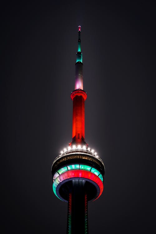 Free From below of glowing contemporary CN tower with colorful lights located in Toronto on dark night on street in city Stock Photo