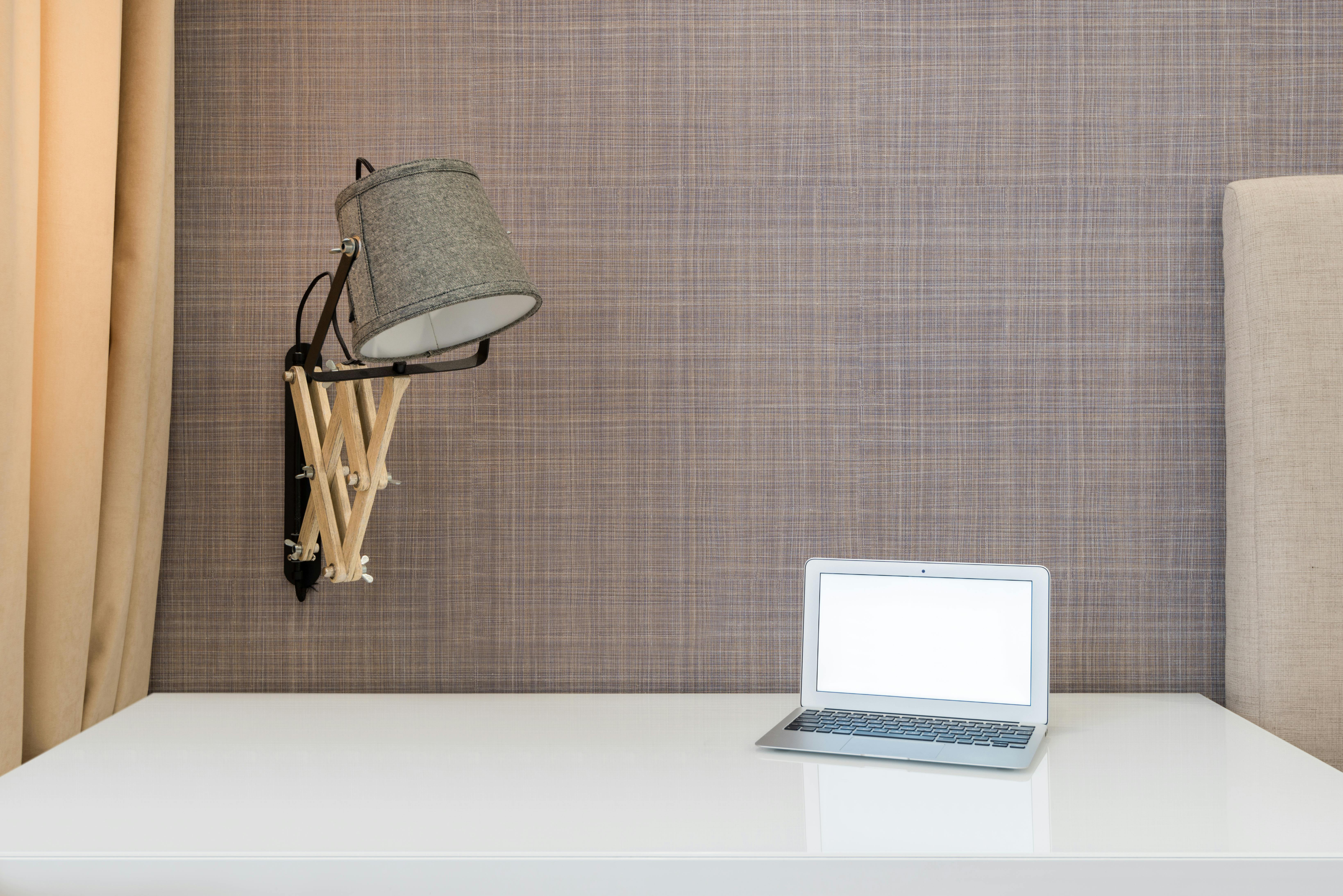 laptop placed on table near lamp in room