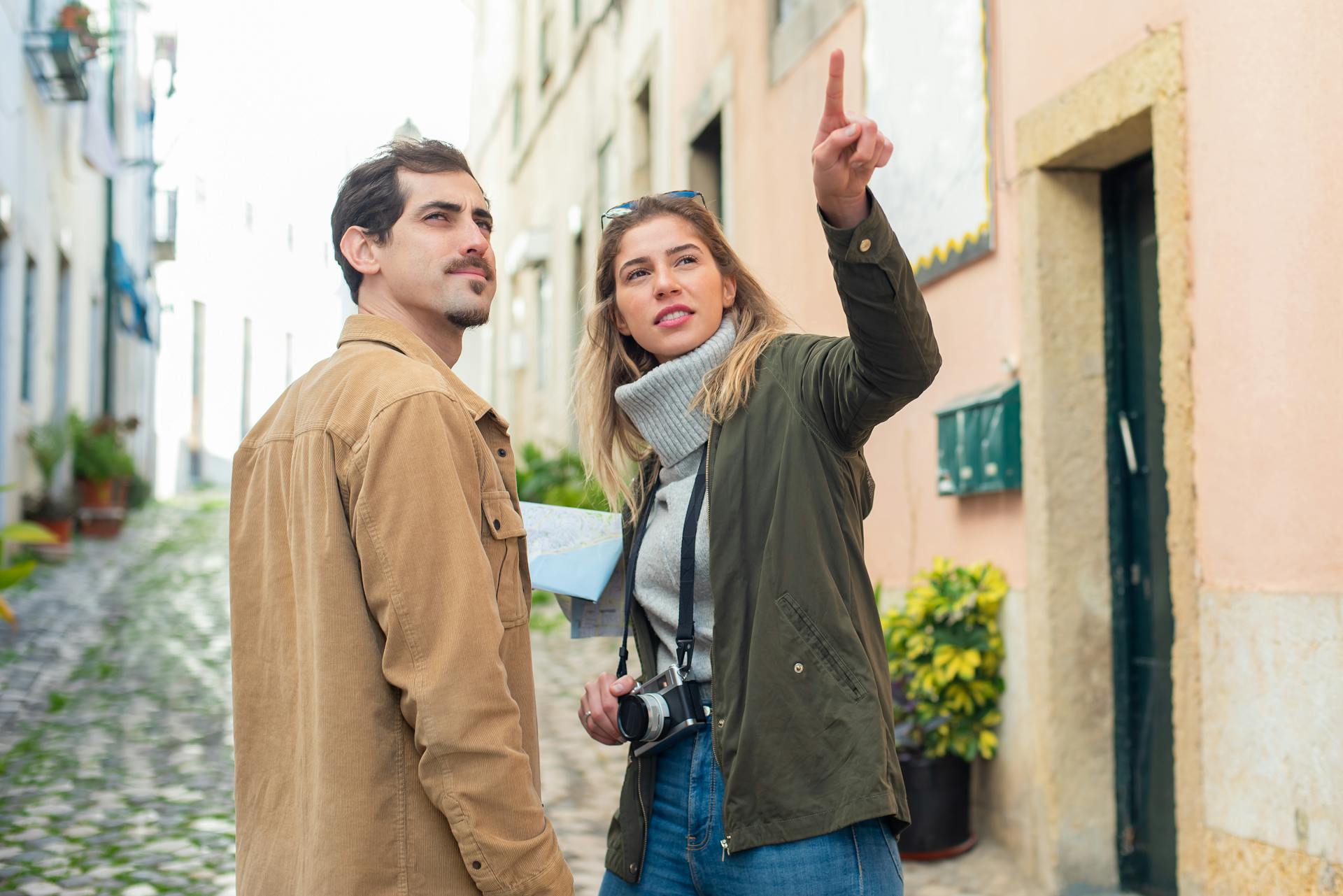 Young couple navigating a European street with a map, showcasing travel adventure.