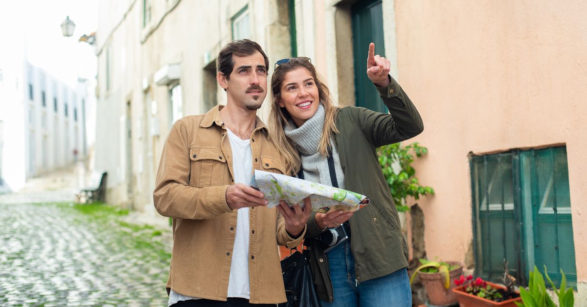 student traveler looking at a map in a European city street with a backpack
