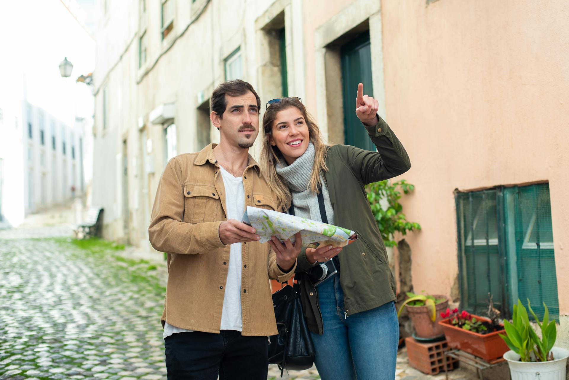 Happy couple exploring a charming European city street with a map. Perfect travel inspiration.