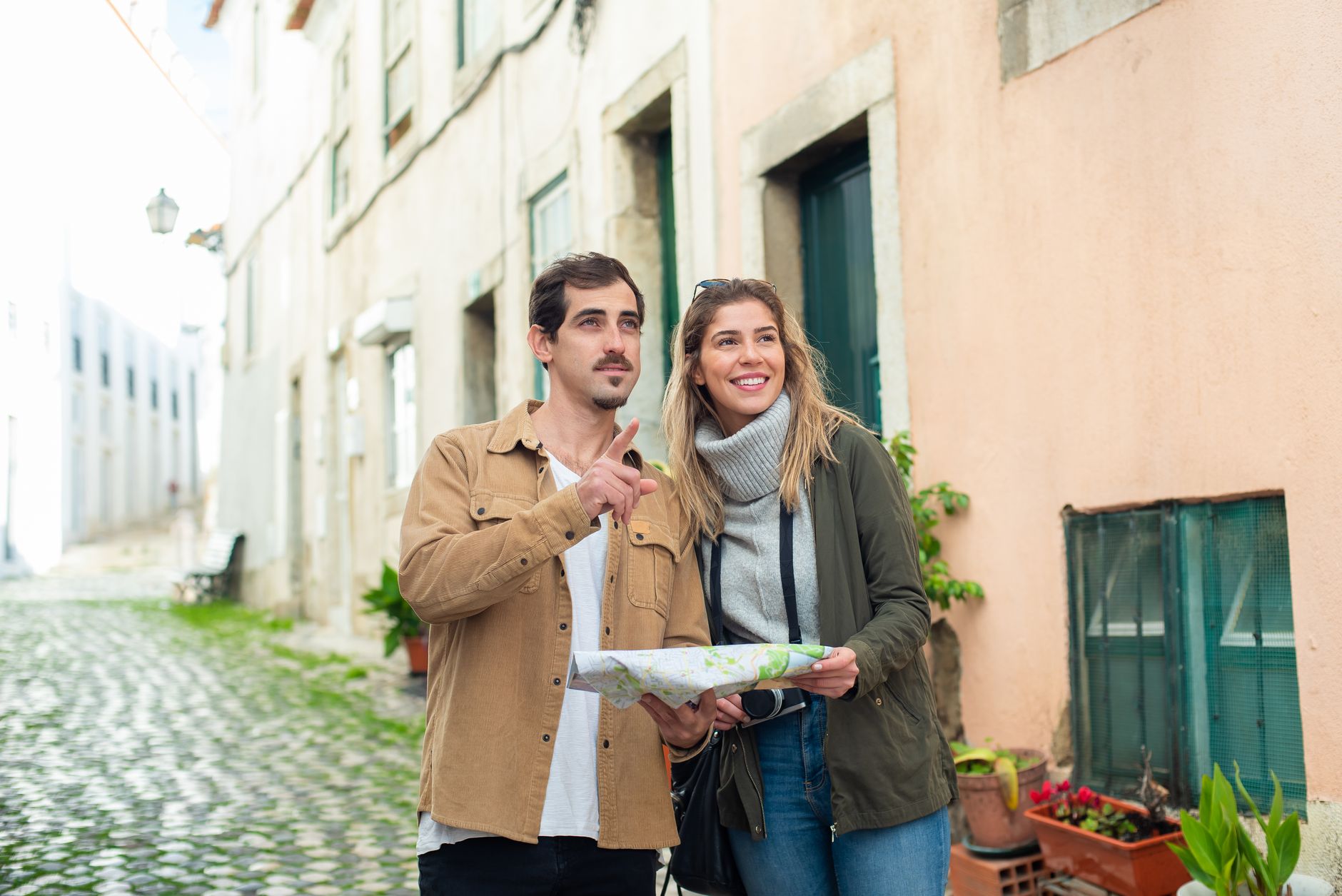 Happy couple exploring a historic city using a map, enjoying a travel adventure together.