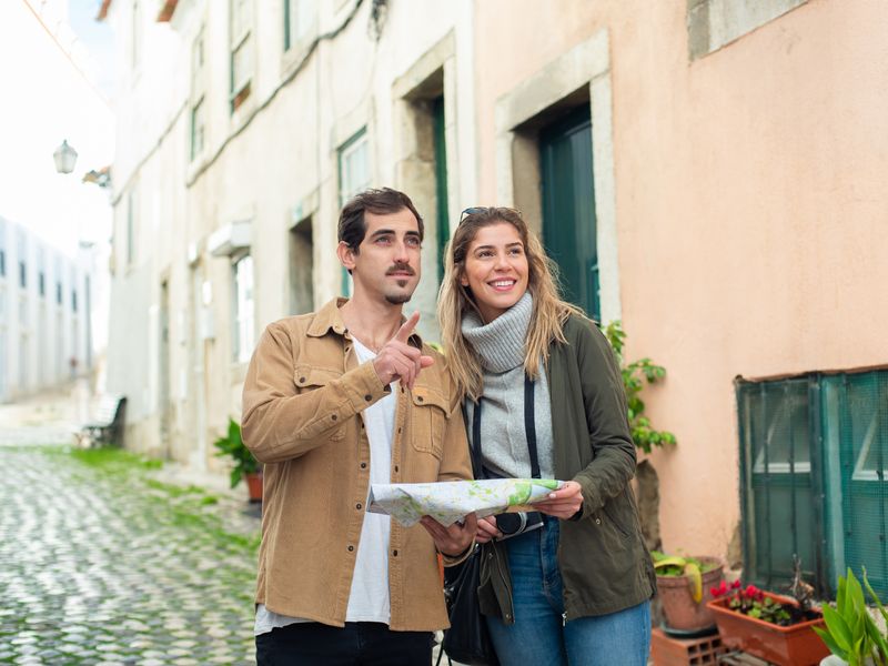 Happy couple exploring a historic city using a map - heritage trail app