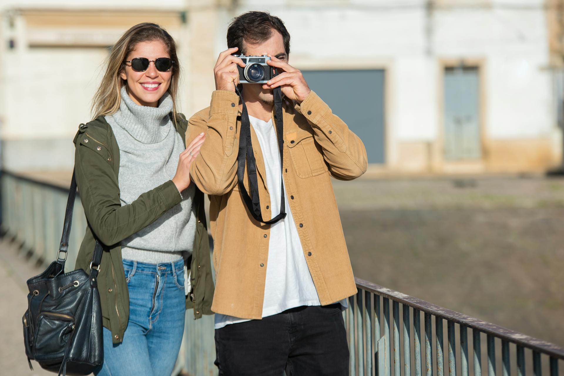 A smiling couple traveling and capturing memories on a bright, sunny day.