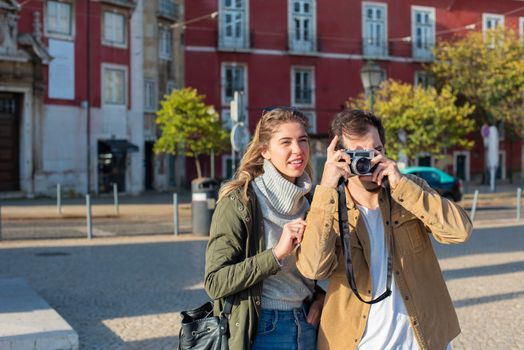 Couple capturing street photos in an urban setting, embracing travel vibes.