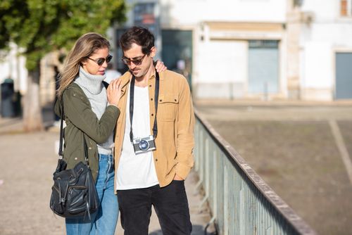 Free A young couple walking together in the city, enjoying a sunny day. Stock Photo