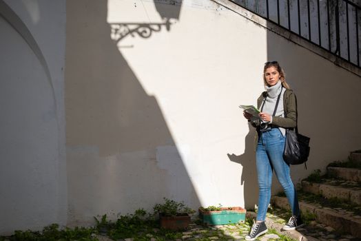 Woman with a map exploring a city street, embracing adventure and travel.